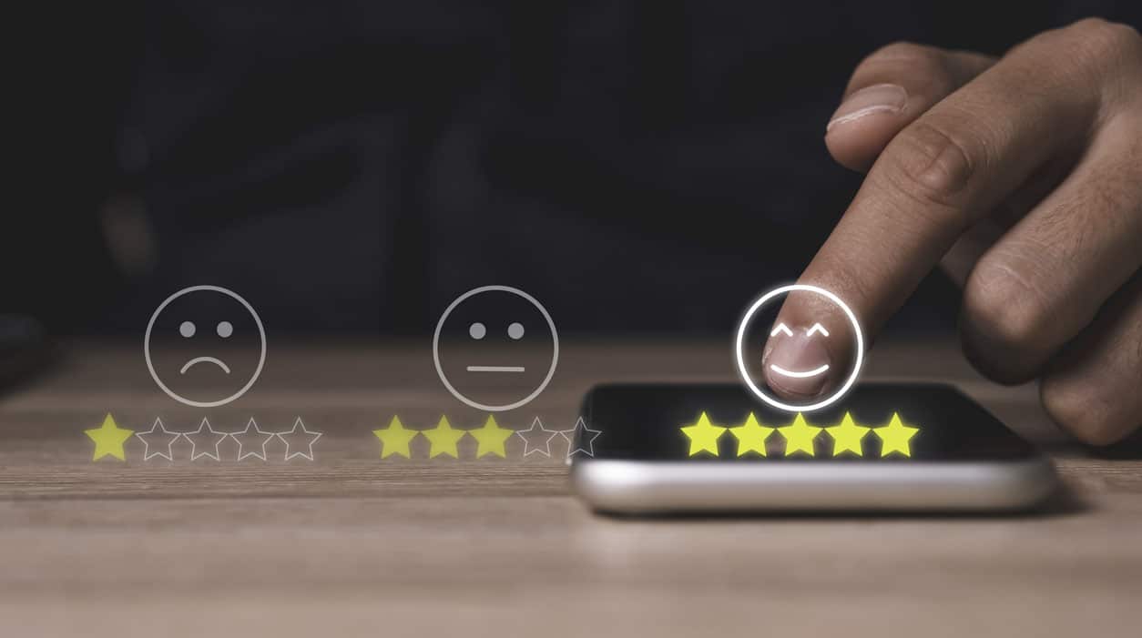 Hand touch on mobile phone to add five yellow stars to customer evaluates products and services. Customer satisfaction and marketing survey rating concept.